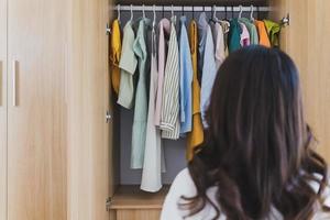 jong Aziatisch vrouw met vol garderobe foto