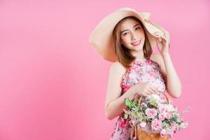 foto van jong Aziatisch meisje vervelend bloem jurk Aan roze achtergrond