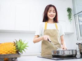 beeld van jong Aziatisch vrouw in de keuken foto