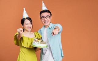 jong Aziatisch paar Holding verjaardag taart Aan achtergrond foto