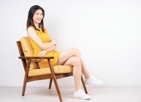 beeld van jong Aziatisch vrouw zittend Aan stoel foto