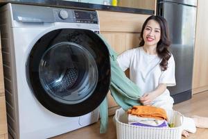 beeld van jong Aziatisch vrouw het wassen kleren foto