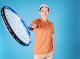 beeld van jong Aziatisch Mens Holding tennis racket foto