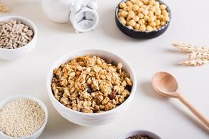 droog muesli, sesam zaden, vlas zaden, zonnebloem zaden, kikkererwten en quinoa in kommen. gezond voedsel. foto