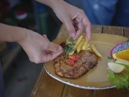 koks hand- bereidt zich voor een gegrild varkensvlees ribben en siert hoor foto