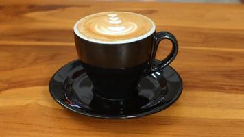een glas van cappuccino koffie met schuim snijwerk Aan de tafel foto