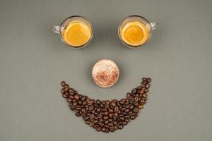 glimlach gezicht gemaakt van koffie bonen en mokken foto