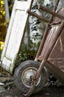een metaal kruiwagen met een wiel gebruikt door arbeiders in bouw of tuinieren. foto