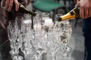 barman giet Champagne in een glas foto