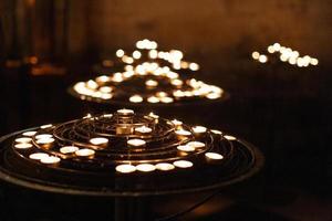 veel ontslagen kaarsen in de kerk Aan een stellage. foto