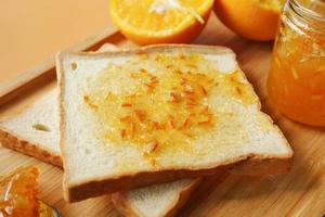 oranje fruit verspreiding Aan een brood Aan tafel foto