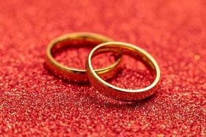 zullen u trouwen mij. twee gouden bruiloft ringen Aan rood schitteren achtergrond. verloving huwelijk voorstel bruiloft concept. st. Valentijnsdag dag ansichtkaart. banier Aan valentijnsdag dag. kopiëren ruimte. foto