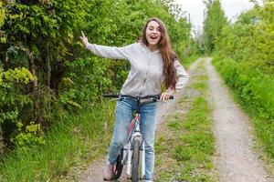 jong vrouw rijden fiets in zomer stad park buitenshuis. actief mensen. hipster meisje kom tot rust en rijder fiets foto