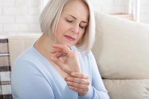 vrouw masseren haar artritis hand- en pols foto