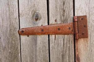 verroest nagemaakt gordijn Aan een houten deur. een deel oud houten deur. schuur. gebarsten. de deur naar de scharnieren. dichtbij omhoog van hout. foto