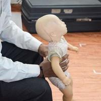 Mens het uitvoeren van cpr Aan baby opleiding pop dummy met een hand- compressie. eerste steun opleiding - cardiopulmonaal reanimatie. eerste steun Cursus Aan cpr pop, cpr eerste steun opleiding concept foto