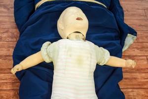 Mens het uitvoeren van cpr Aan baby opleiding pop dummy met een hand- compressie. eerste steun opleiding - cardiopulmonaal reanimatie. eerste steun Cursus Aan cpr pop, cpr eerste steun opleiding concept foto