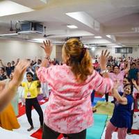 Delhi, Indië, juni 19 2022 -groep yoga aerobics sessie voor mensen van verschillend leeftijd groepen in balaj tempel, levend vihar, Internationale yoga dag, groot groep van volwassenen Bijwonen aerobics klasse in tempel foto