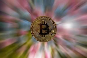 single bitcoin munt of icoon staand in scherp focus Aan een reflecterende oppervlakte met goud gekleurde foto