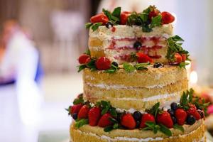 bruiloft taart met Open biscuit zandkoekjes, room en fruit. bosbessen, aardbeien, frambozen, rood krenten. foto