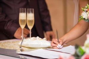 de bruid schrijft met een pen, detailopname van vrouw hand- schrijven Aan papier foto