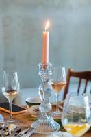 roze kaars in een kandelaar Aan een tafel detailopname met bril van wijn en Champagne foto