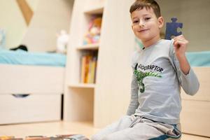 jongen Verbinden decoupeerzaag puzzel stukken in een kinderen kamer Aan verdieping Bij huis. pret familie werkzaamheid vrije tijd. foto