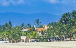 zon strand mensen golven en boten in puerto escondido Mexico. foto