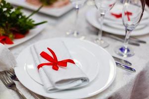Kerstmis tafel lay-out, rood plakband met een kaneel stok, rozemarijn en een plak van droog oranje Aan de donker houten achtergrond met Kerstmis decoraties foto