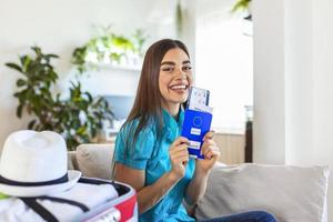 vrouw is voorbereidingen treffen voor reizen gedurende covid-19 pandemie. Holding paspoort, ticket en negatief coronavirus test in hand- terwijl koffer is staand in de buurt. zomer reizen en vakantie concept foto