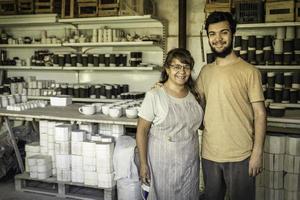 vrouw en zoon glimlachen en op zoek Bij de camera in de keramiek studio. foto