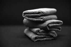 drie grijs handdoeken Aan een zwart achtergrond. badstof doeken voor afvegen meubilair. handdoeken Aan een zwart achtergrond. foto