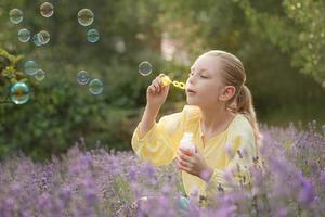 mooi weinig meisje in een veld- met lavendel. foto