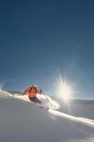 skiër Aan een zonnig dag van vers sneeuw foto