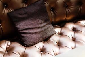 wijnoogst luxueus bruin leer sofa met drie kleding stof kussens. foto