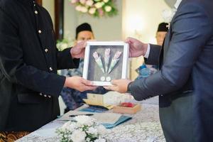 twee mannen Holding bruiloft geschenk doos in een traditioneel bruiloft ceremonie in Indonesië foto