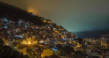 nacht over- braziliaans favelas Aan de heuvel met stad downtown onderstaand, Rio de janeiro, Brazilië foto