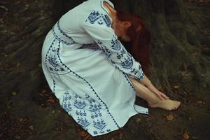 dichtbij omhoog moe blootsvoets vrouw in borduurwerk jurk concept foto