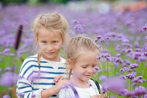 meisjes wandelen buitenshuis in bloemen veld- foto