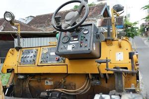 asfalt afmaker, voorkant detail van geel asfalt weg bouw machine geparkeerd Aan de kant van de weg foto