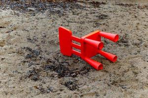 een klein rood stoel in een zandbak foto