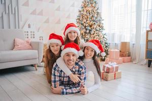 gelukkig jong familie met kinderen Holding Kerstmis presenteert foto