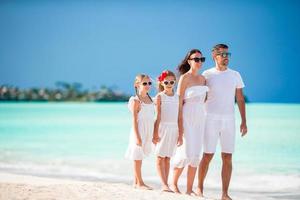 jong familie wandelen Aan wit tropisch caraïben strand foto