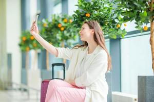 mooi vrouw in Internationale luchthaven. toerist met smartphone binnen- foto