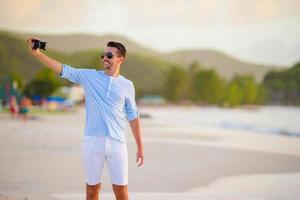mooi jong Mens nemen een zelf foto haarzelf Aan tropisch strand