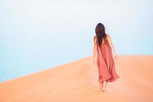 meisje tussen duinen in woestijn in Verenigde Arabisch emiraten foto