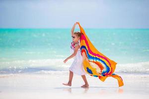 weinig meisje hve pret Aan de strand. kind genieten strand vakantie met pareo foto