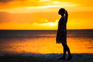 mooi vrouw Aan wit strand Bij zonsondergang. foto