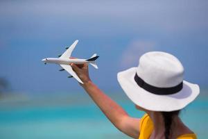 weinig wit speelgoed- vliegtuig Aan achtergrond van turkoois zee foto