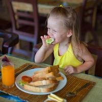 schattig weinig meisje hebben ontbijt Bij toevlucht restaurant foto